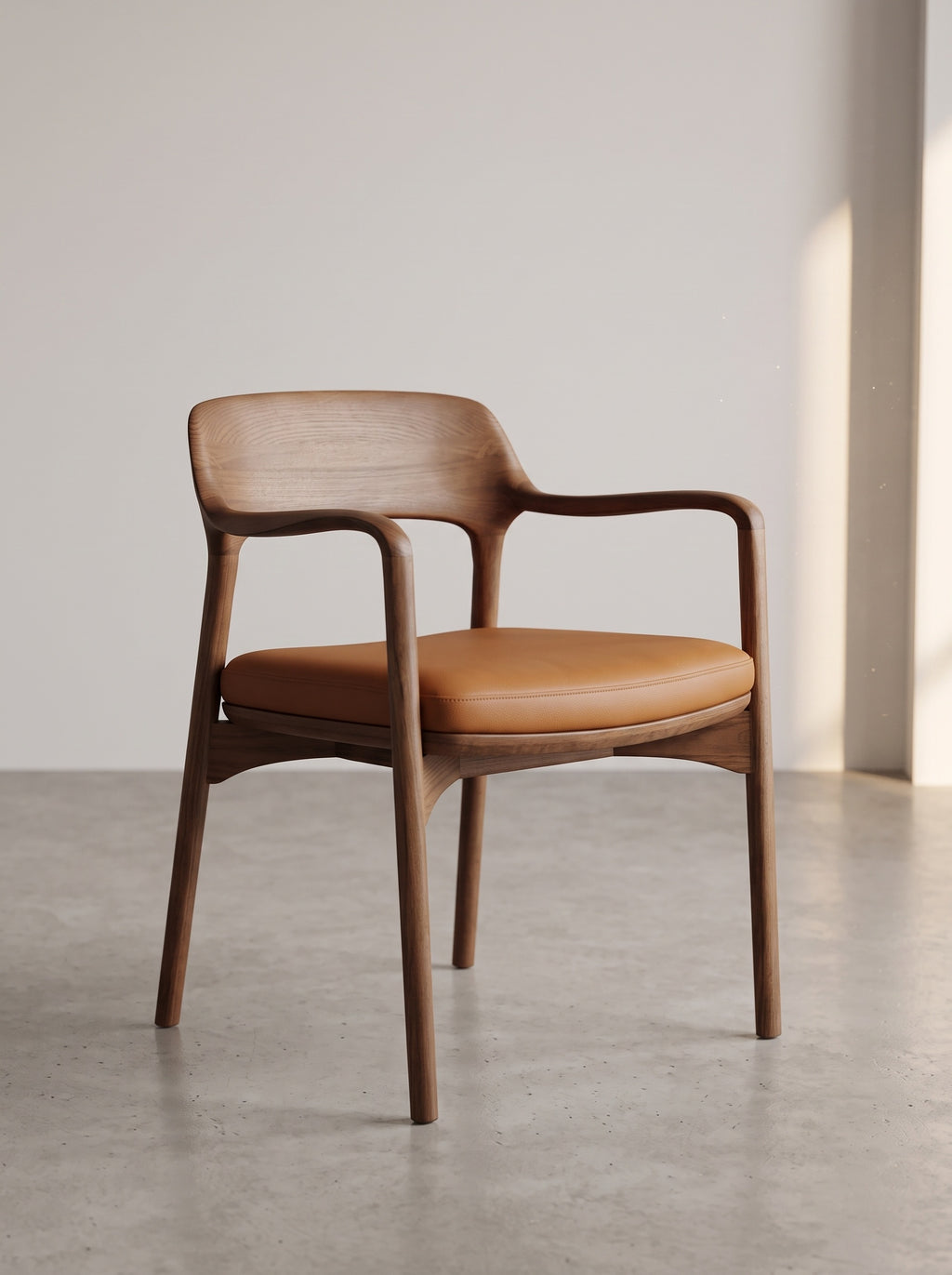 A mid-century modern wooden dining chair with a warm brown wood frame and a tan leather seat cushion, set against a minimalist light gray wall and concrete floor.